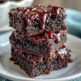 Festive 4th of July Firecracker Brownie Bites with red, white, and blue sprinkles on creamy vanilla frosting.  
