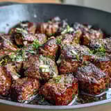 One-Pan Garlic Herb Steak Bites sizzling in a cast iron skillet, tender and aromatic with fresh parsley and thyme.  