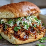 Hearty vegan BBQ pulled jackfruit piled high on toasted buns with coleslaw.