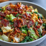 Golden-brown fried cabbage with savory bacon and caramelized onions, a classic comfort side.
