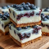 Deliciously zesty, no-bake lemon blueberry cheesecake bars ready to slice.