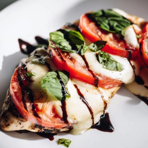 Golden-brown Caprese Chicken Skillet breasts topped with melted mozzarella, fresh tomato slices, and torn basil leaves.