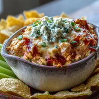Creamy Crock Pot Buffalo Chicken Dip bubbling in a slow cooker, topped with melted cheese and fresh scallions for a spicy, game-day appetizer.