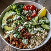 Freshly shredded rotisserie chicken, fluffy brown rice, and crisp veggies topped with creamy tzatziki and fresh herbs.