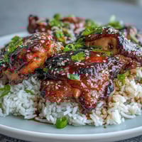 Honey garlic chicken with rice, tender chicken in a glossy sauce served over fluffy jasmine rice.